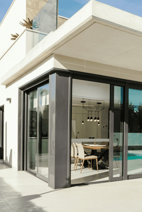 Pr2 Modern villa with floor-to-ceiling glass doors by the pool, dining area visible inside